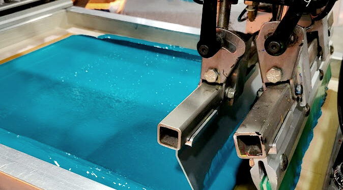 Screen printing t-shirts in production using professional printing equipment